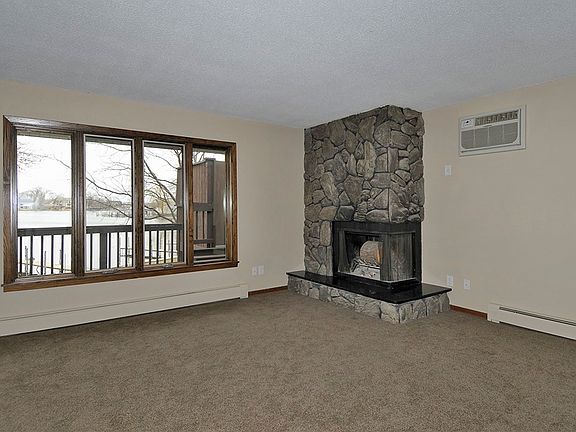 The living room boasts new carpeted floors, a wood burning f