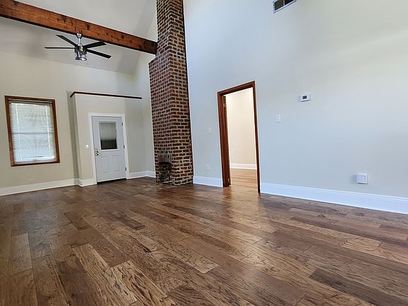 Entry room with Cathedral Ceiling, exposed beams, and engineered wood flooring.