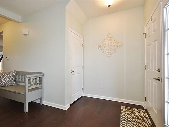 Welcoming foyer with hardwood floors, coat closet and open to the living room.