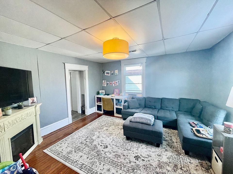 Spacious Living Room w/ Beautiful Original Hardwood Floors. High Ceilings and Two Large Windows for Natural Lighting. NEW DESIGNER SHERWIN WILLIAMS FRENCH GRAY PAINT AND NEW BLACK DRUM LINEN LIGHTING TO BE INSTALLED!