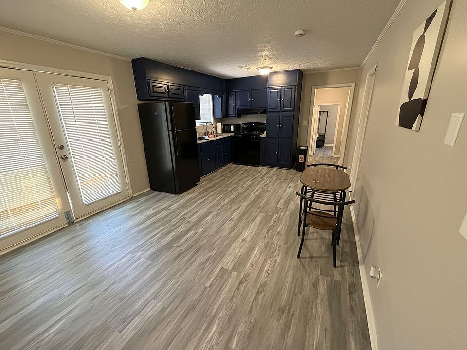 Open kitchen area with generous cabinet storage, full-size appliances, and durable plank flooring plus nearby exterior access