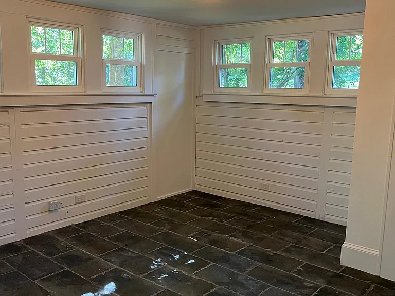 Third bedroom off of the kitchen, split from the other bedrooms, provides privacy and a different style, as its finished with reclaimed slate tiles. It also makes for a prime home gym location, yoga/mediation studio or flourishing plant sanctuary.