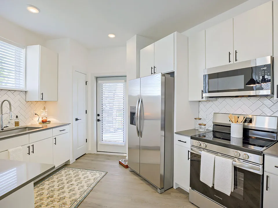 Every detail is dialed in _ full stainless steel appliance packages, herringbone tile backsplash, and a convenient back door make this kitchen as functional as it is beautiful. Garrett Harvest Junction West, Longmont, CO.