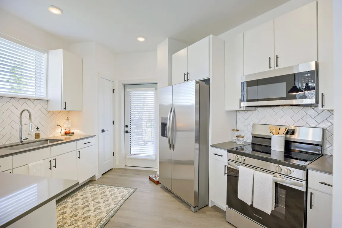 Every detail is dialed in _ full stainless steel appliance packages, herringbone tile backsplash, and a convenient back door make this kitchen as functional as it is beautiful. Garrett Harvest Junction West, Longmont, CO.