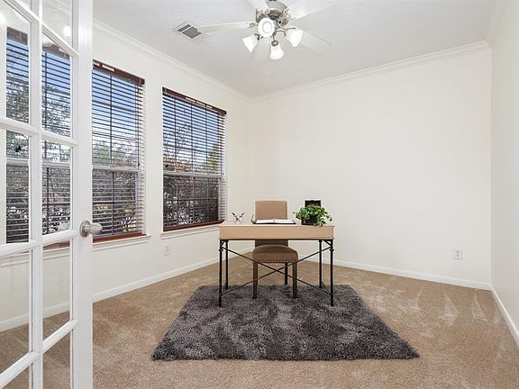 Handsome study with French doors for added privacy. Study features recent carpet, crown molding and a wall of windows providing lots of natural sunlight.