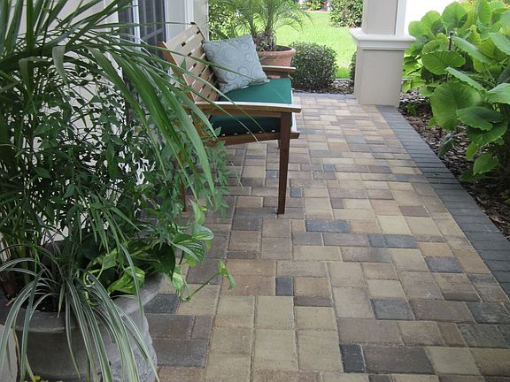 A pavered walk and large porch greets visitors.