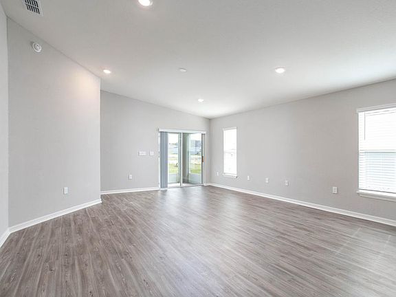 The open-concept living area has ample space and opens to the screened lanai - New home for sale in