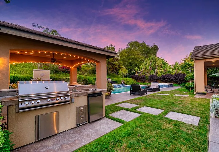 Outdoor kitchen features extra large grill, fridge and sink for easy entertaining.