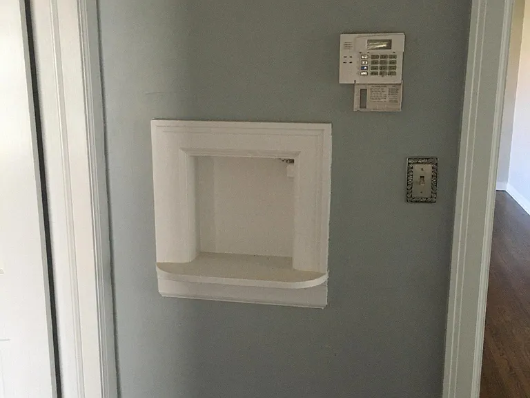 The house still has some of its original charm with phone nook in hallway