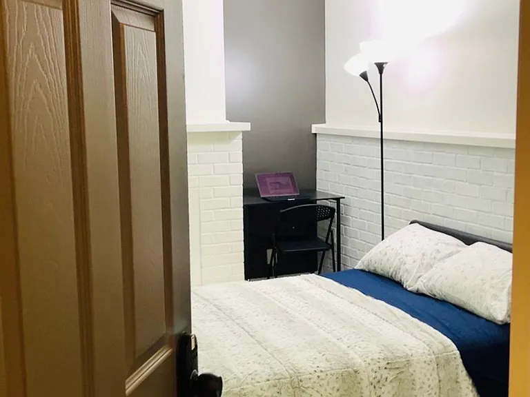 Furnished private bedroom with a full bed, desk workspace, and easy-care flooring for comfortable everyday living.