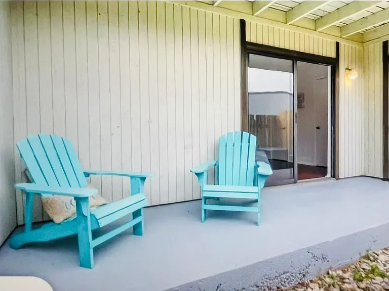 Private outdoor patio with lounge chairs. Small fenced-in green space to enjoy the outdoors.