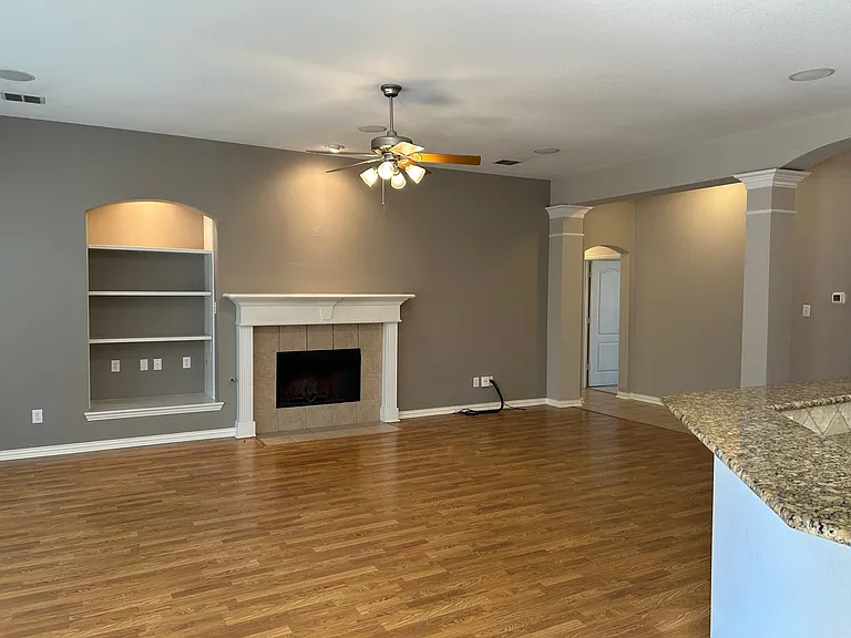Spacious living room with fireplace open to the kitchen.