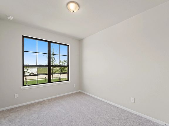 The secondary bedroom features plush carpet, fresh paint, closet, and a large window that lets in pl