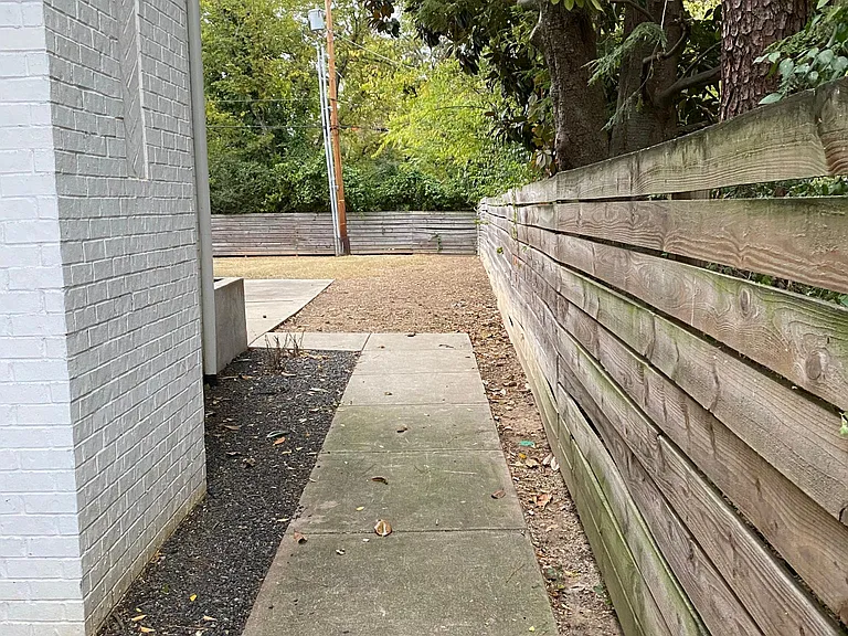 Sidewalk to fenced in area/backyard