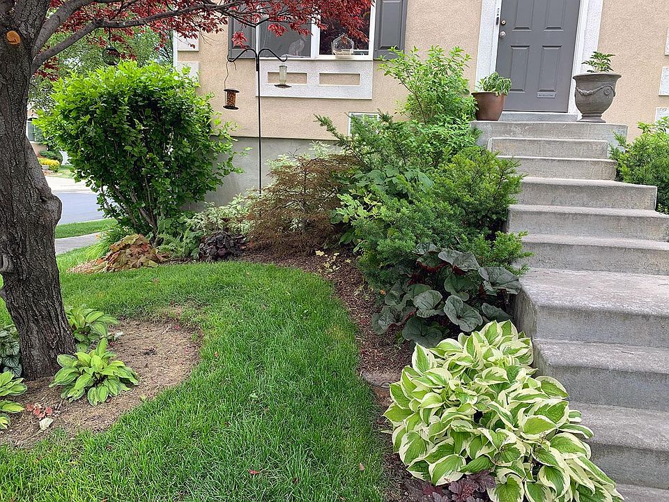 Front entrance with custom landscaping, smart-lock with keypad, and smart security camera.