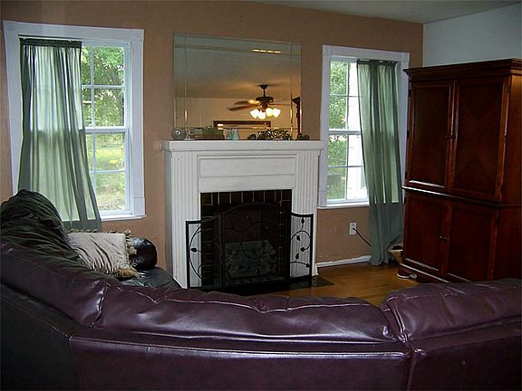 Large living room with mock fire place .