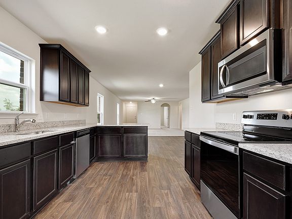 The kitchen boasts beautiful granite countertops and designer wood cabinetry.