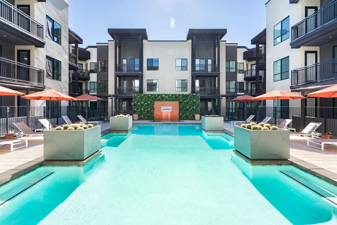 A striking pool courtyard at Modera Higley Commons, where crisp lines, resort-style seating, and a serene water feature define the outdoor experience.