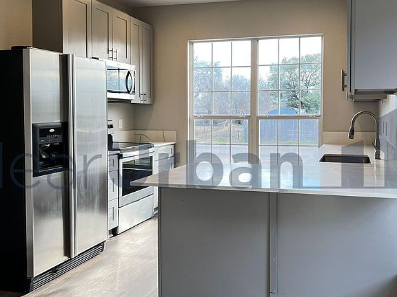 Kitchen w/ brand-new stainless-steel appliances.