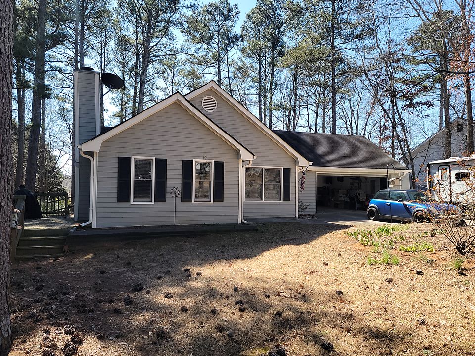 View of house with deck on left and 2 car garage.