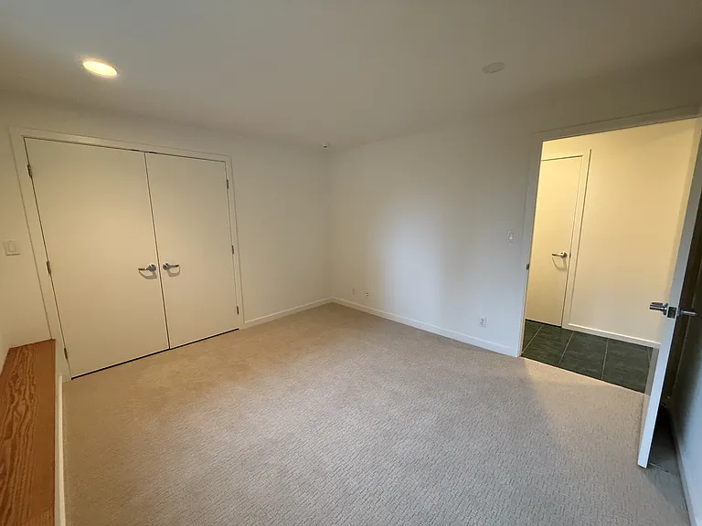 Third bedroom has a spacious closet and comfortable plush carpets, located adjacent to another hallway bathroom.