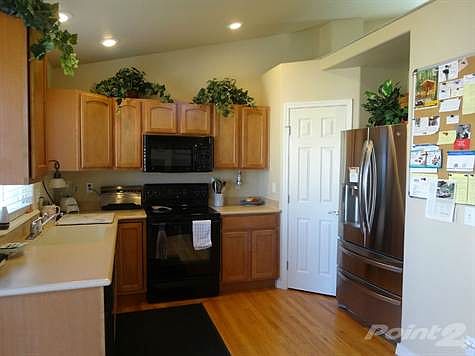 Kitchen: The Kitchen Boasts Corian Countertops, Polished Hardwood Flooring, and Large Pantry.