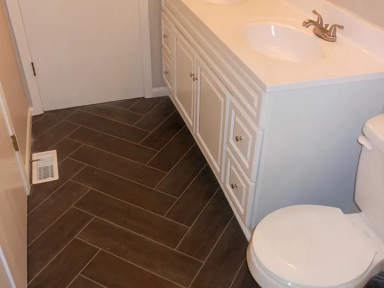 Herringbone tile flooring in full bathroom
