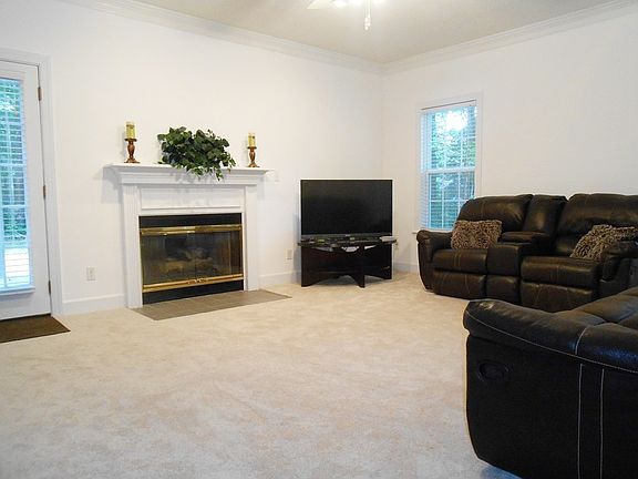 Interior View : Family room with fireplace. Doors lead to Rear Deck and Front Porch.