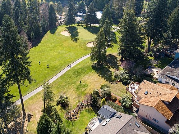 Extend your living outdoors to the large entertainment sized deck that wraps around the backside of the home. A spiral staircase off of the deck leads down to the lower level patio where you can also find a golf cart garage. Large bonus family room downstairs with a built-in bar, fireplace and sweeping views. An additional large guest bedroom downstairs features a cozy wood burning fireplace.