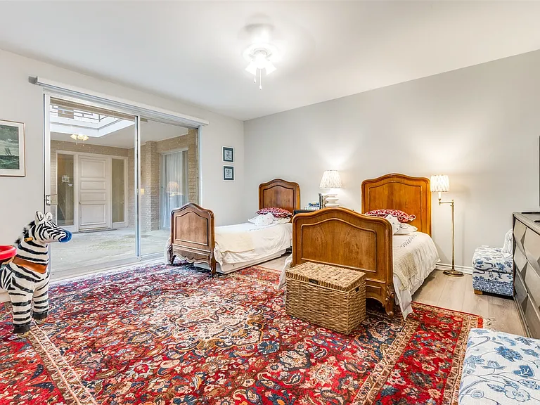 Room featuring light wood-finish flooring, white walls, and a ceiling fan