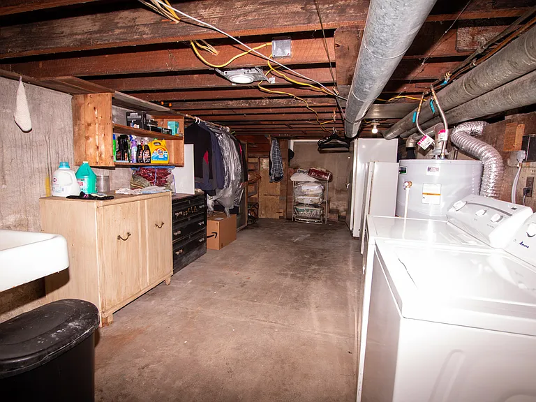 Basement has plenty storage space and is equipped with washer/dryer as well as a utility sink and a work desk
