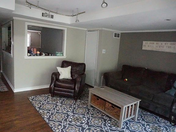 View from entering into the front door. Kitchen is in middle with back room viewable. Bedroom located to the left, opposite the efficiency kitchen.