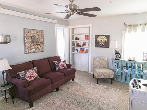 Living room area with TV, sitting area and ceiling fan