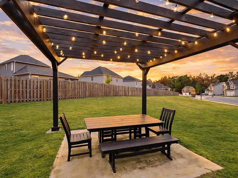 Charming backyard pergola accented with ambient lighting for evening relaxation.