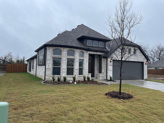Baywindow and glass main entry door with 2 car garage and a shade tree, Cedar Posts with a touch of elegance
