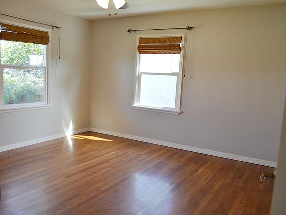 Large bedroom, freshly painted with new light gray color scheme. Original hardwood floors. Double pane windows