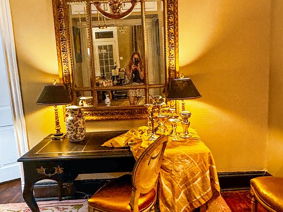 Statement parlor with giant gilt mirror and colorful carpet.