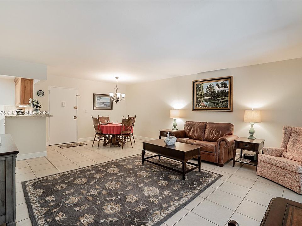 Living room facing kitchen, entrance and dining area.