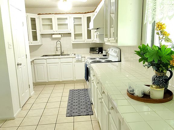 Well-equipped kitchen with plenty of counter space, ceramic tile countertops, and a large sink. Ready for all your cooking and hosting needs!