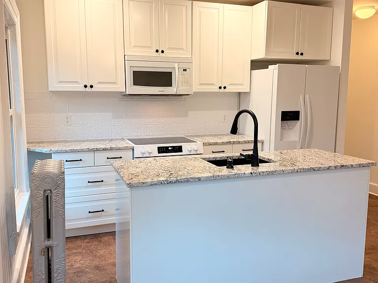 Refinished kitchen with granite, updated appliances, and fixtures.