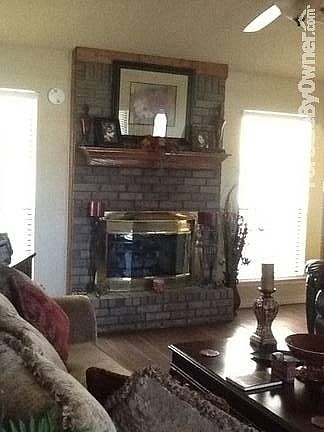 Gas log fireplace, wood look ceramic tile floors, cathedral ceiling.