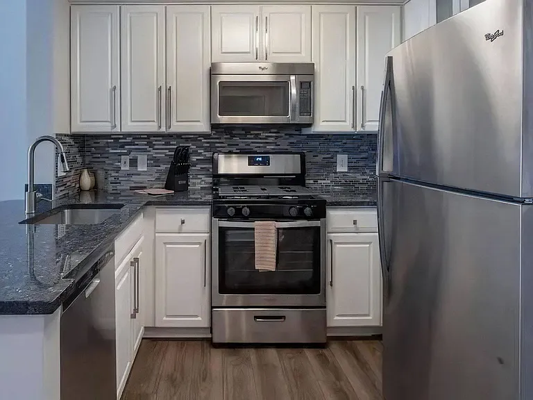 U-Shaped Kitchen With Stainless Steel Appliances and Granite Countertops