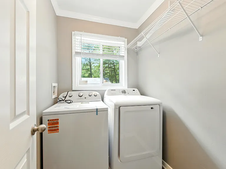 Convenient laundry room with brand-new washer & dryer!
This light and bright laundry space comes equipped with a new washer and dryer set, plus a handy storage shelf.