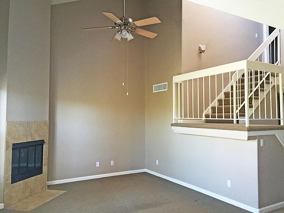 Living area includes high ceilings, ceiling fan, and fireplace