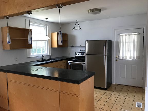 Tile in the kitchen. Appliances have been recently installed. Concrete counters and custom cabinets.