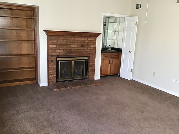 living room with fire pl book shelf