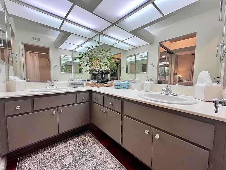 Primary ensuite full bath with dual sinks, hair dryer, and starter toiletries for convenience perfect if you forget something essential like your toothbrush!