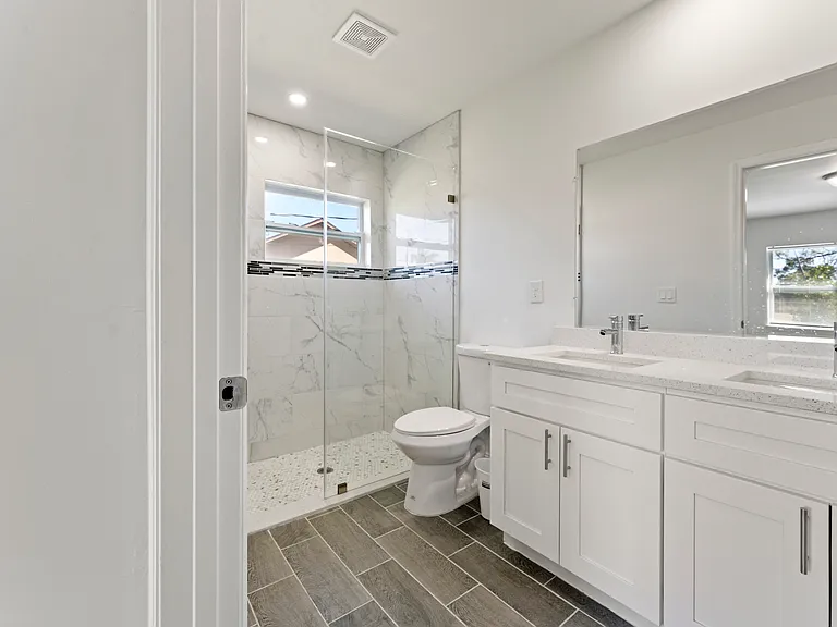 Master bathroom with his/her sinks and walk-in shower