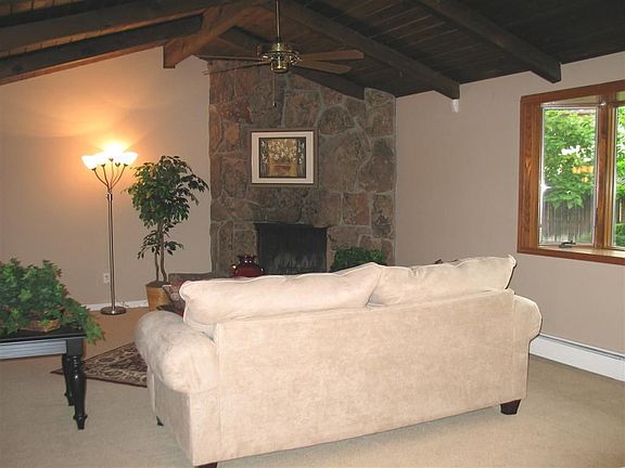Living room with stone fireplace and bay window
