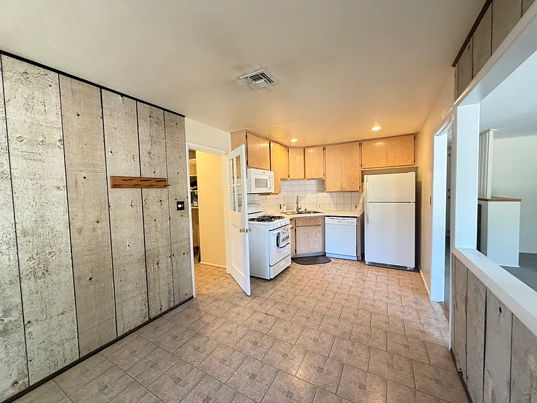 View from dining area showing kitchen and laundry room access.